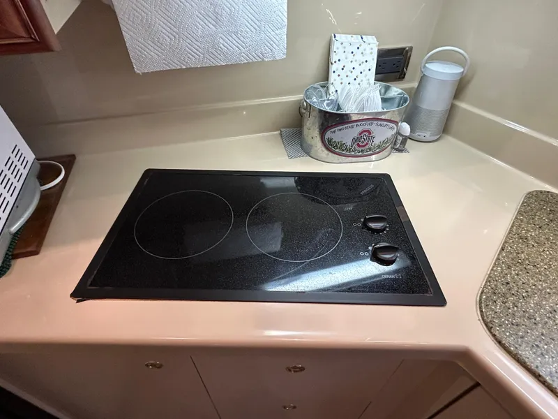 Slide: The Image of Stovetop in 2001 Cruisers Yachts 3470 Express kitchen area with countertop and accessories. - 33