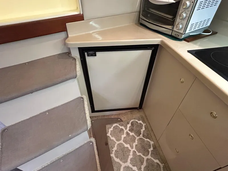 Slide: The Image of 2001 Cruisers Yachts 3470 Express galley with compact fridge and oven. - 34