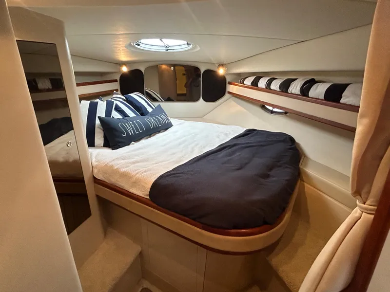 Slide: The Image of 2001 Cruisers Yachts 3470 Express cabin with cozy bed and nautical decor. - 41