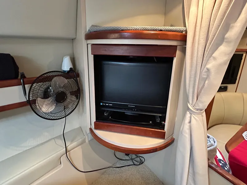 Slide: The Image of 2001 Cruisers Yachts 3470 Express interior with TV, fan, and curtain. - 44