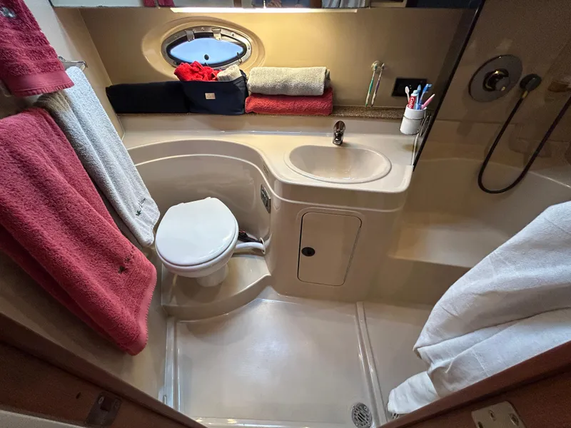 Slide: The Image of 2001 Cruisers Yachts 3470 Express bathroom with sink, toilet, and towels. - 47