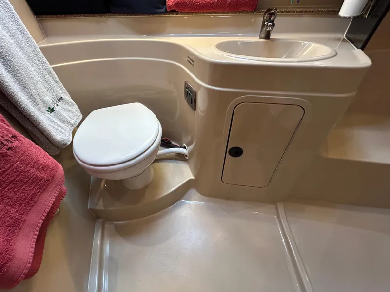 Slide: The Image of 2001 Cruisers Yachts 3470 Express bathroom with toilet, sink, and towels. - 48