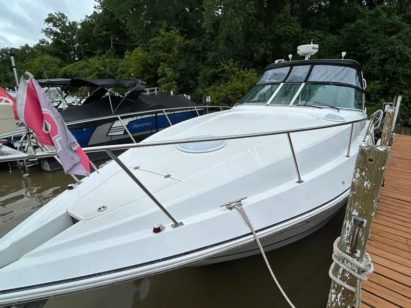 Slide: The Image of 2001 Cruisers Yachts 3470 Express docked, featuring sleek white design and spacious deck. - 5