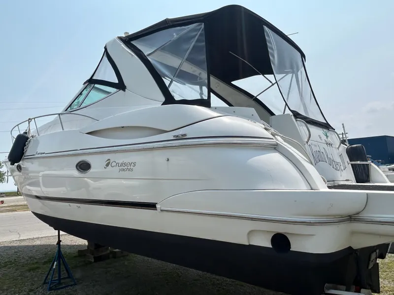 Slide: The Image of 2001 Cruisers Yachts 3470 Express boat with black canopy, docked on land. - 75
