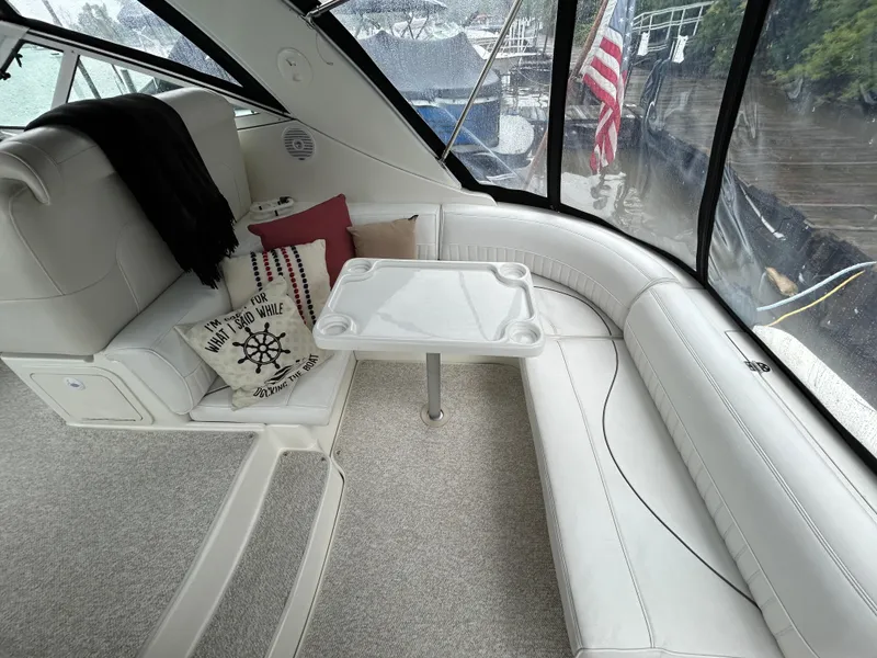 Slide: The Image of 2001 Cruisers Yachts 3470 Express interior with white seating and decorative pillows. - 8