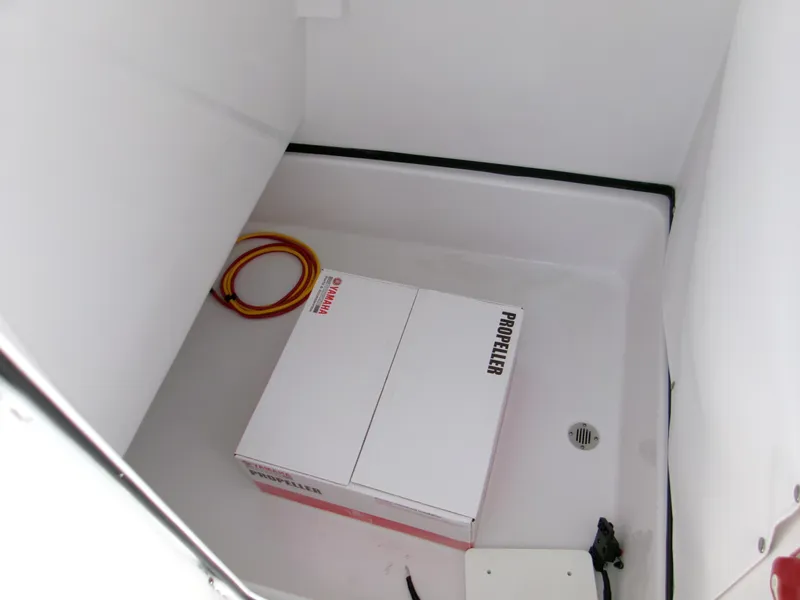 Slide: The Image of 2025 Sportsman Masters 247OE Bay Boat storage compartment with propeller box and coiled cable. - 12