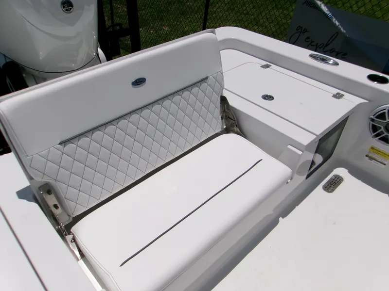 Slide: The Image of 2025 Sportsman Masters 247OE Bay Boat with white cushioned seating and storage compartments. - 18