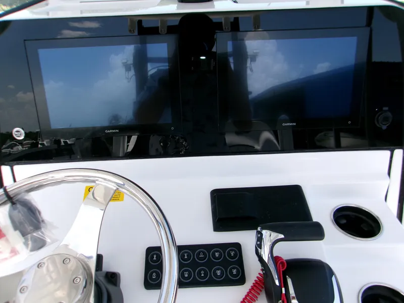 Slide: The Image of 2025 Sportsman Masters 247OE Bay Boat dashboard with dual Garmin displays and controls. - 9