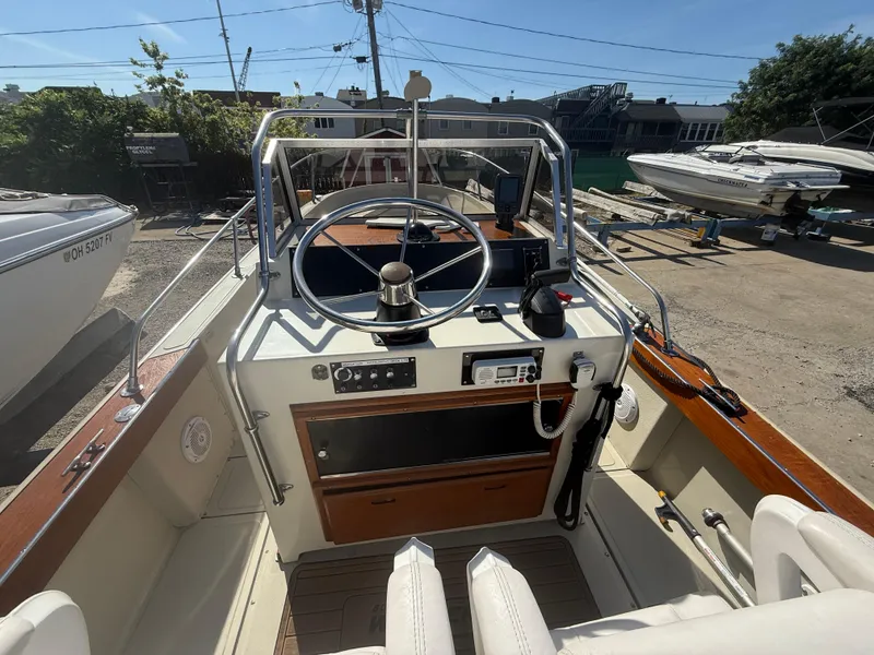 Slide: The Image of 1980 Boston Whaler 22 boat interior with steering wheel and control panel. - 10