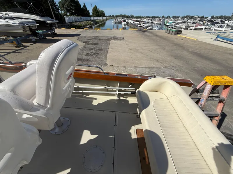 Slide: The Image of 1980 Boston Whaler 22 boat interior with white seating at marina dock. - 11