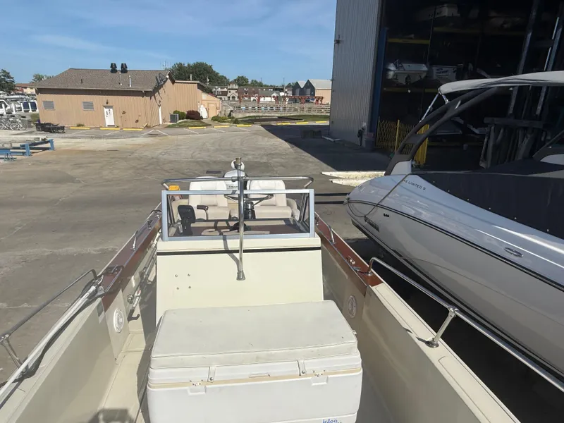 Slide: The Image of 1980 Boston Whaler 22 boat docked near a marina, with clear skies above. - 12