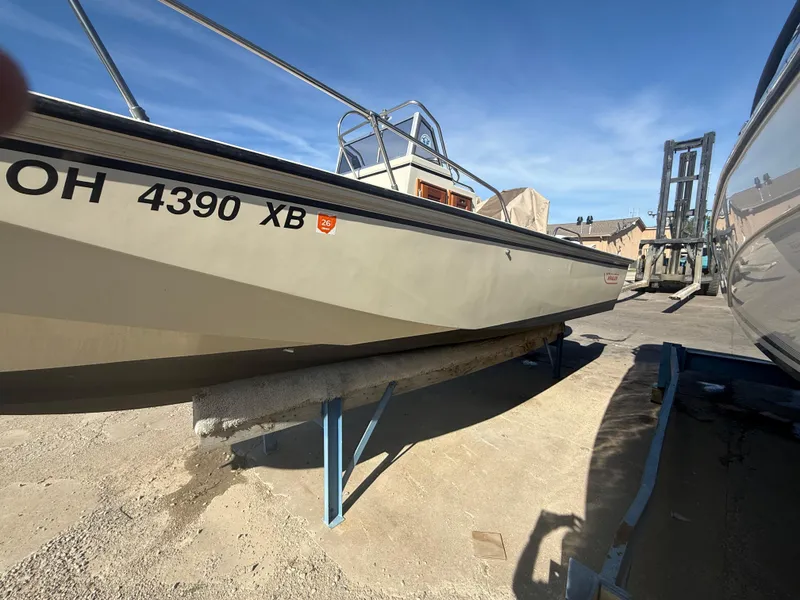 Slide: The Image of 1980 Boston Whaler 22 boat on trailer, parked outdoors under clear blue sky. - 8