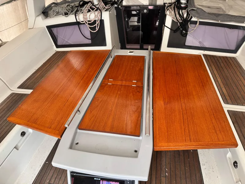 Slide: The Image of Interior view of 2014 Beneteau Oceanis 48 sailboat with wooden table and seating area. - 12