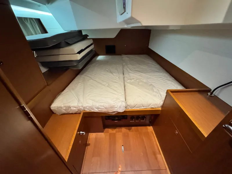Slide: The Image of 2014 Beneteau Oceanis 48 cabin interior with bed and wooden cabinetry. - 19