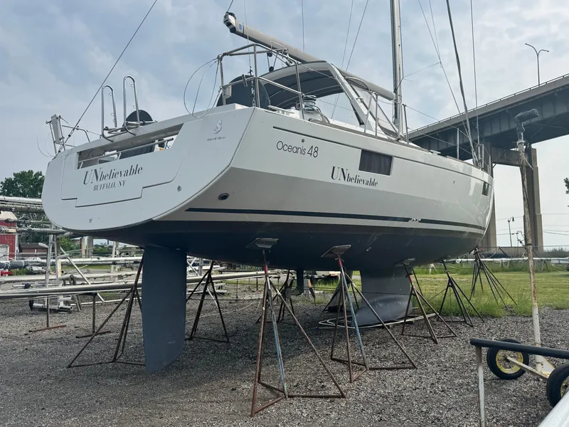 Slide: The Image of 2014 Beneteau Oceanis 48 sailboat on stands, outdoor storage, overcast sky. - 2