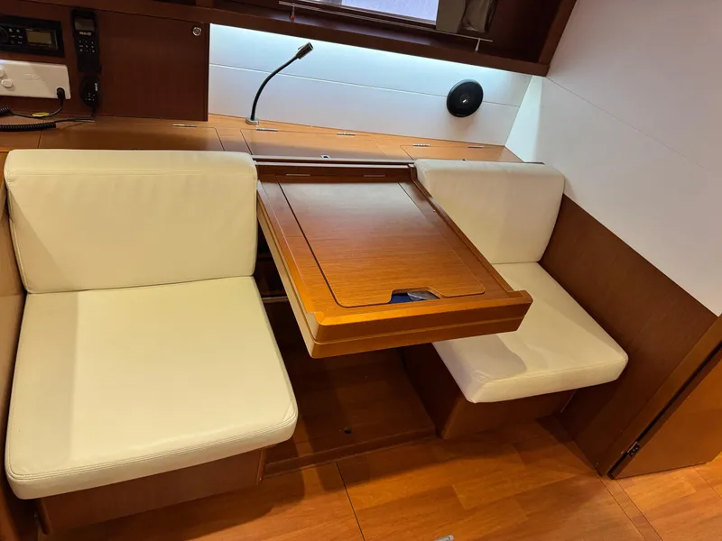 Slide: The Image of Interior of 2014 Beneteau Oceanis 48 yacht with wooden table and cream seating. - 24