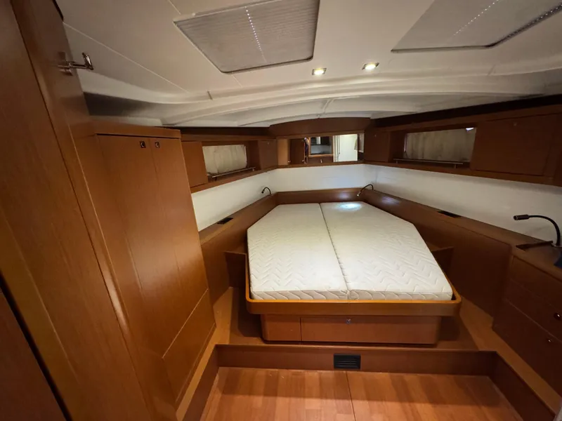 Slide: The Image of 2014 Beneteau Oceanis 48 cabin interior with wooden finish and double bed. - 26