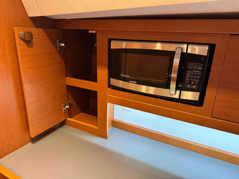 Slide: The Image of Microwave and wooden cabinets in 2014 Beneteau Oceanis 48 yacht kitchen. - 34
