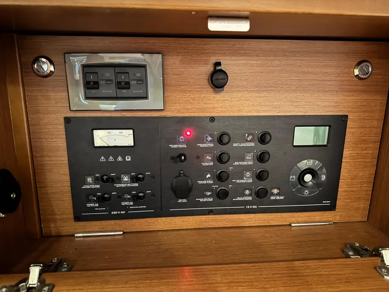 Slide: The Image of Control panel of a 2014 Beneteau Oceanis 48 sailboat, featuring various switches and gauges. - 44