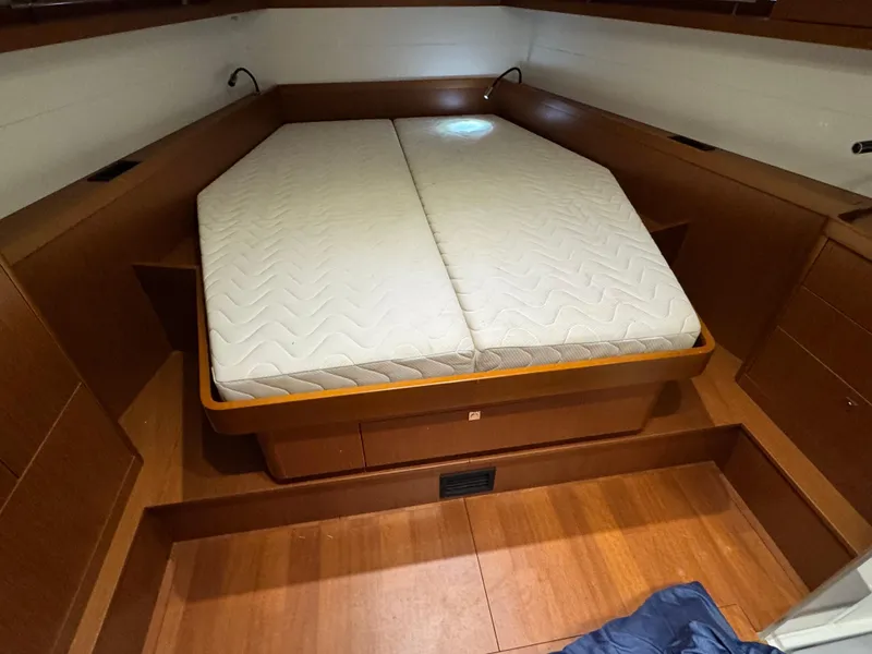 Slide: The Image of Cabin interior of 2014 Beneteau Oceanis 48 with a double bed and wooden finish. - 48