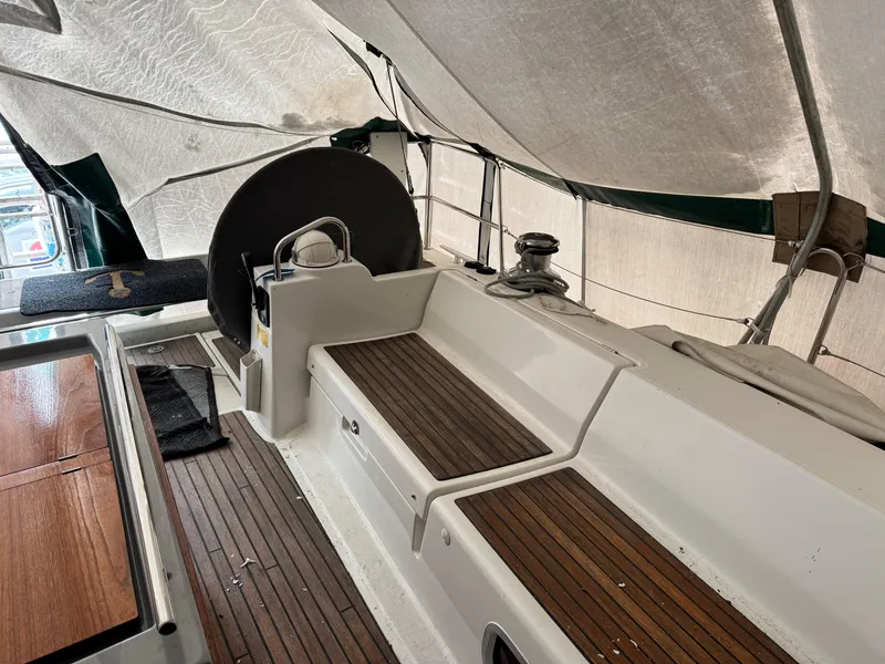 Slide: The Image of Interior view of 2014 Beneteau Oceanis 48 sailboat with wooden seating and covered deck. - 9