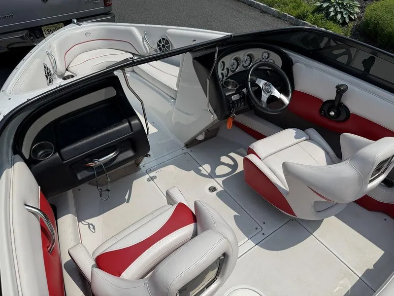 Slide: The Image of 2013 Crownline 185 SS boat interior with white and red seating, steering wheel, and dashboard. - 15