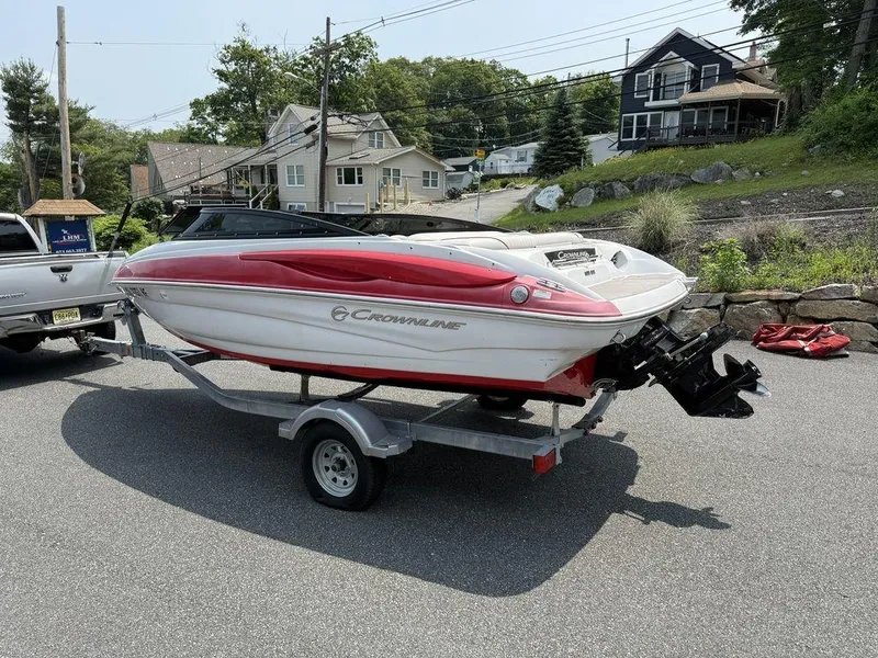 Slide: The Image of 2013 Crownline 185 SS boat on trailer, parked outdoors near houses. - 9