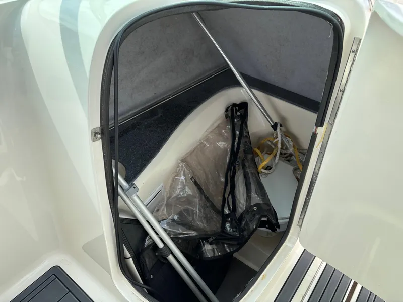 Slide: The Image of Storage compartment of a 2009 Bryant 268 boat, featuring various equipment and accessories. - 13