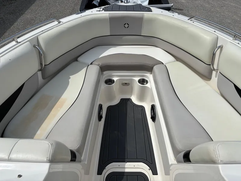 Slide: The Image of Bow seating area of a 2009 Bryant 268 boat with cushioned seats and cup holders. - 7