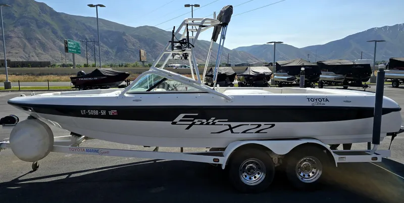 Slide: The Image of 2000 Toyota Epic 22 boat on trailer, parked outdoors with mountains in background. - 9