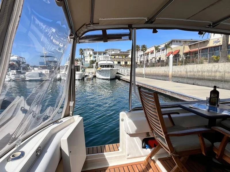 Slide: The Image of 1996 Sea Ray 370 Sedan Bridge yacht docked at marina, featuring outdoor seating and waterfront view. - 11