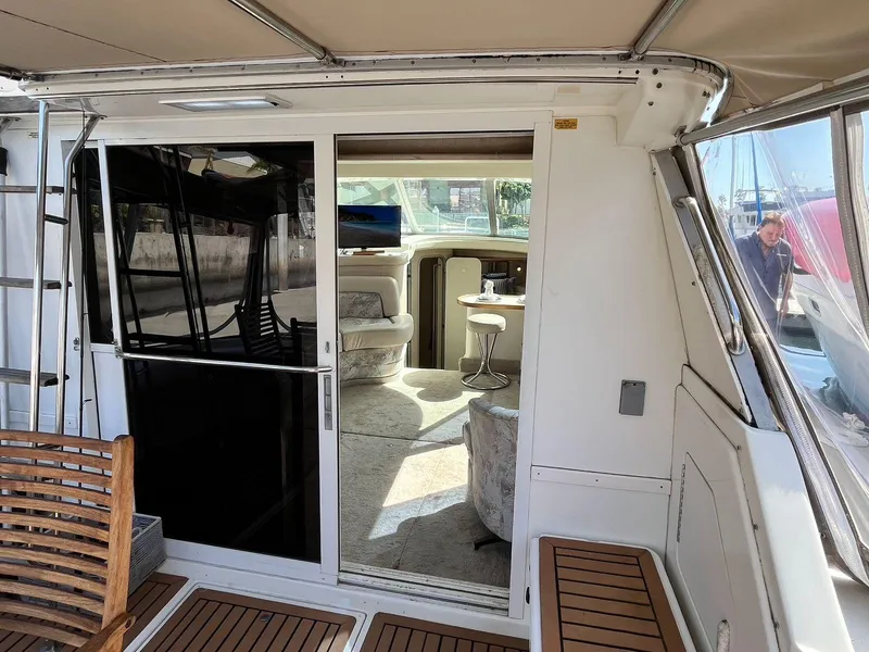 Slide: The Image of 1996 Sea Ray 370 Sedan Bridge interior view with seating and table. - 13