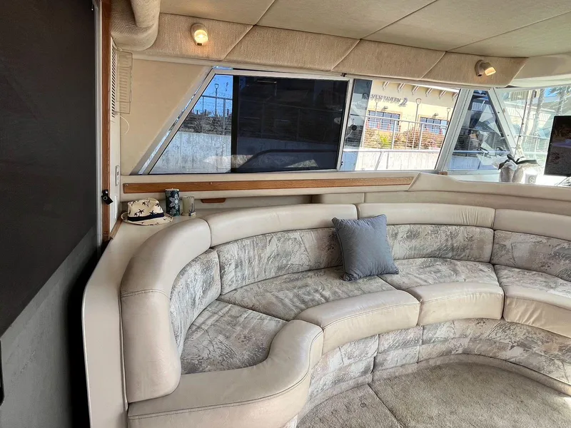 Slide: The Image of Luxurious interior of 1996 Sea Ray 370 Sedan Bridge with curved seating and large windows. - 16