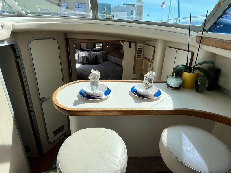 Slide: The Image of Interior of 1996 Sea Ray 370 Sedan Bridge with elegant dining setup. - 23