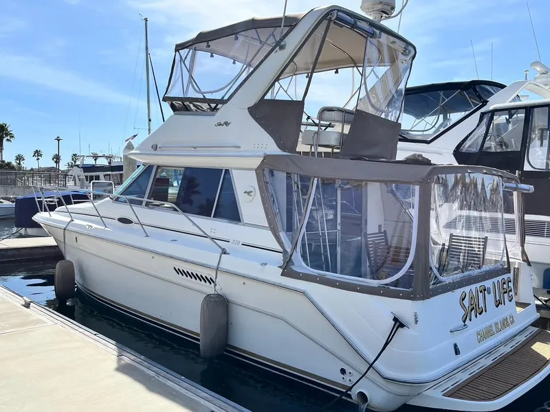 Slide: The Image of 1996 Sea Ray 370 Sedan Bridge yacht docked at marina, featuring enclosed flybridge. - 3