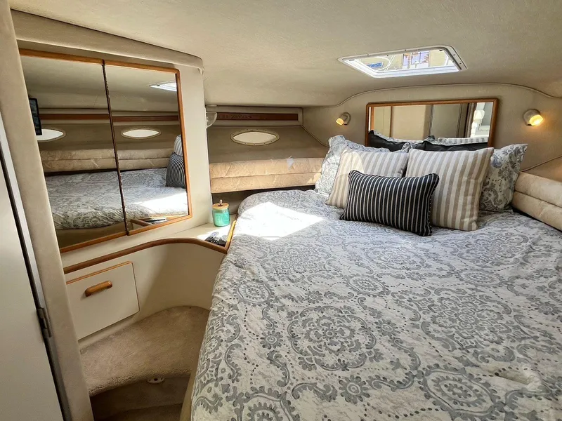 Slide: The Image of Luxurious cabin interior of 1996 Sea Ray 370 Sedan Bridge with elegant bedding and mirrors. - 30