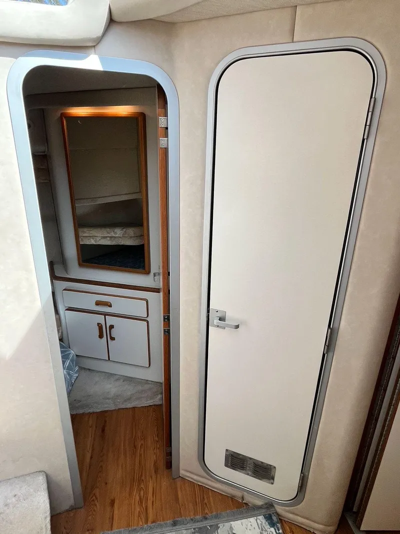 Slide: The Image of Interior view of 1996 Sea Ray 370 Sedan Bridge, featuring cabin door and wooden flooring. - 33