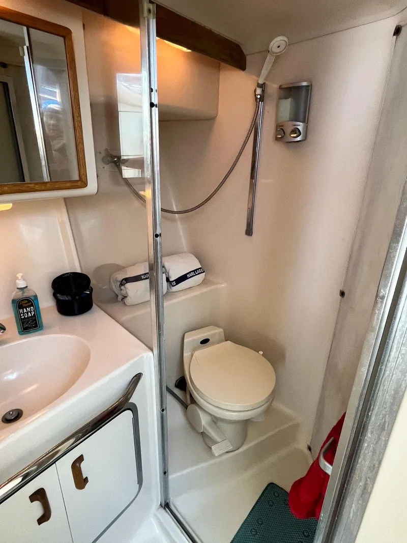 Slide: The Image of Bathroom interior of a 1996 Sea Ray 370 Sedan Bridge yacht, featuring a shower and toilet. - 36