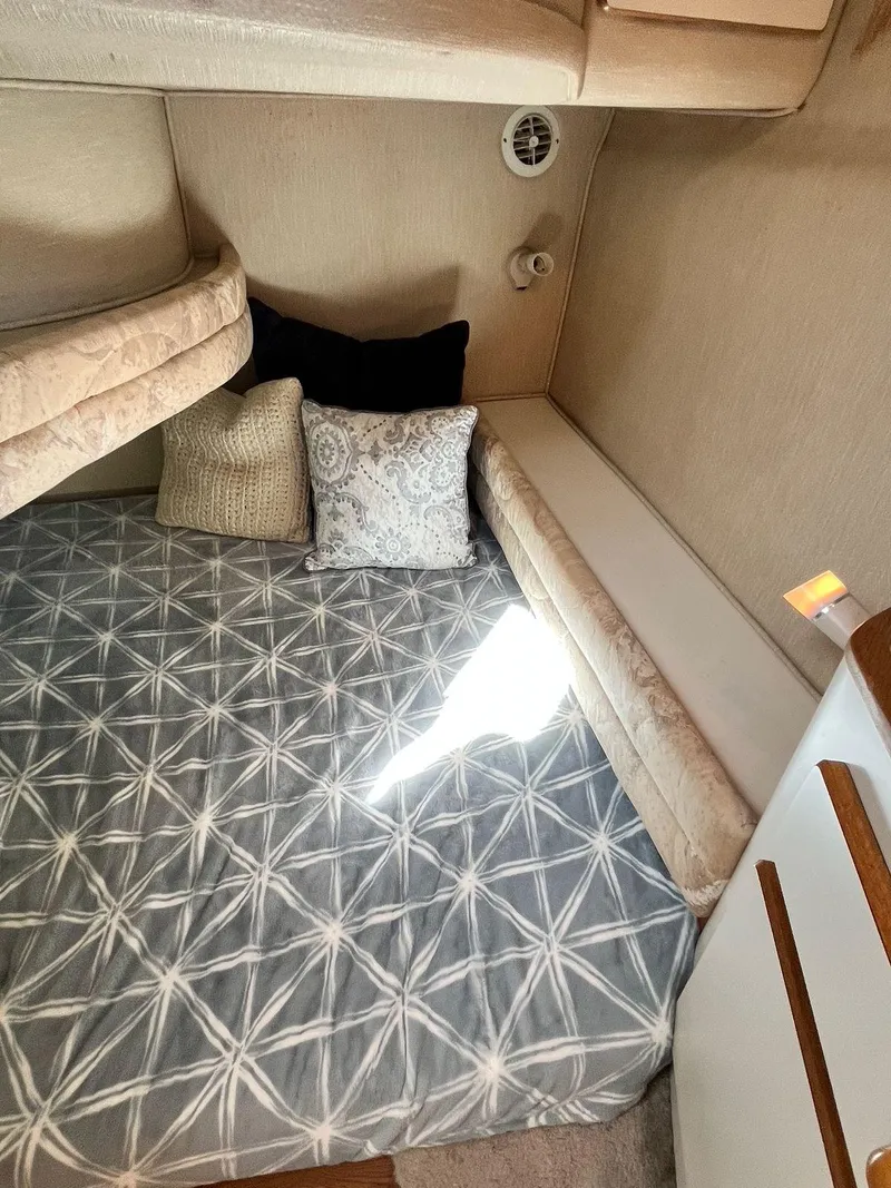 Slide: The Image of Cozy cabin interior of 1996 Sea Ray 370 Sedan Bridge with patterned bedding and cushions. - 38