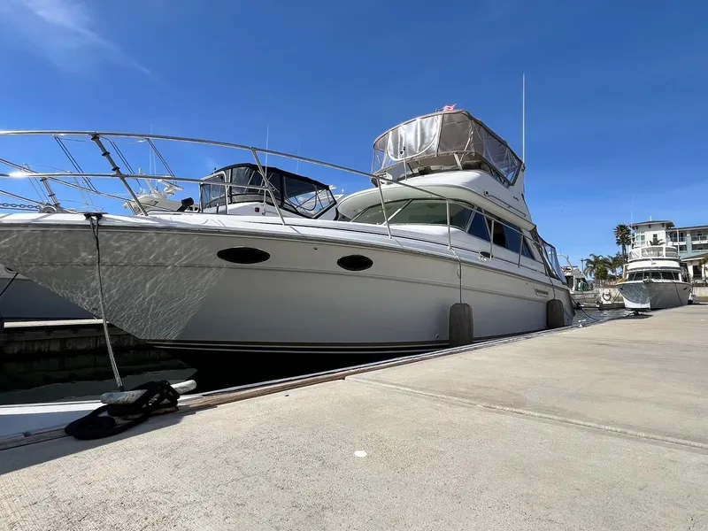 Slide: The Image of 1996 Sea Ray 370 Sedan Bridge yacht docked under clear blue sky. - 4