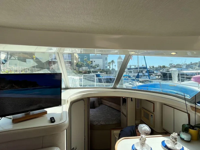 Slide: The Image of Interior view of 1996 Sea Ray 370 Sedan Bridge yacht with marina backdrop. - 47