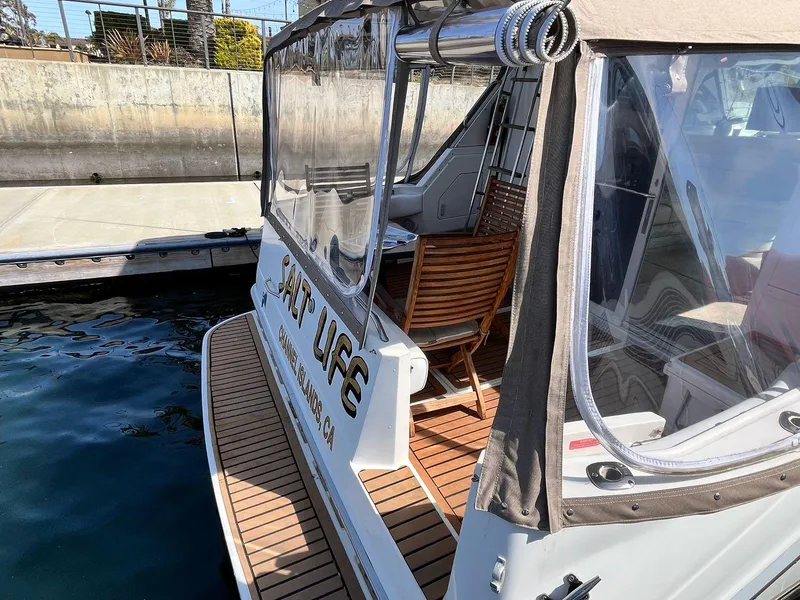 Slide: The Image of 1996 Sea Ray 370 Sedan Bridge docked, featuring a wooden deck and clear canopy. - 8