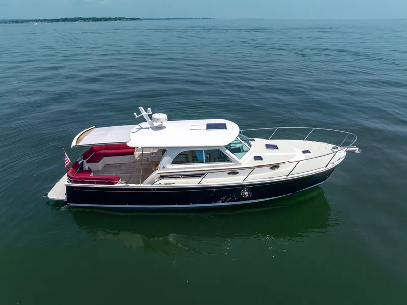 Slide: The Image of 2018 Back Cove Downeast 37 yacht on calm water, featuring sleek design and spacious deck. - 10