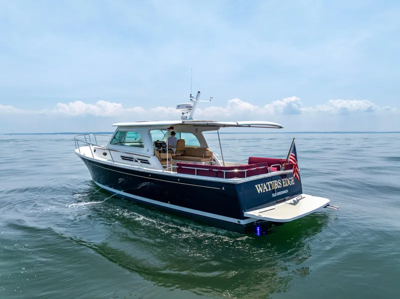 Slide: The Image of 2018 Back Cove Downeast 37 yacht cruising on calm waters under a clear sky. - 11
