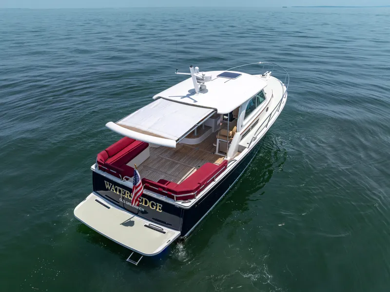 Slide: The Image of 2018 Back Cove Downeast 37 yacht cruising on open water, rear view. - 12