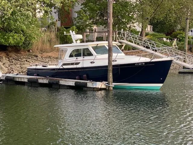Slide: The Image of 2018 Back Cove Downeast 37 boat docked in a serene marina setting. - 13