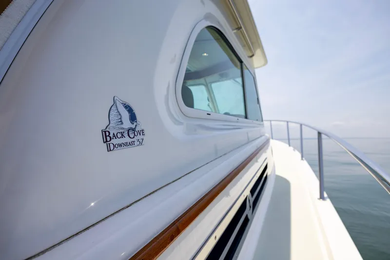 Slide: The Image of 2018 Back Cove Downeast 37 yacht, side view with logo, on calm water. - 17