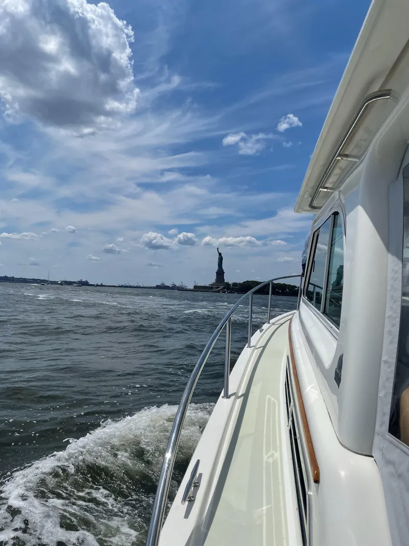 Slide: The Image of 2018 Back Cove Downeast 37 cruising near the Statue of Liberty under a blue sky. - 18