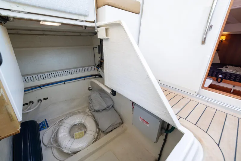 Slide: The Image of 2018 Back Cove Downeast 37 storage compartment with life ring and cabin access. - 23