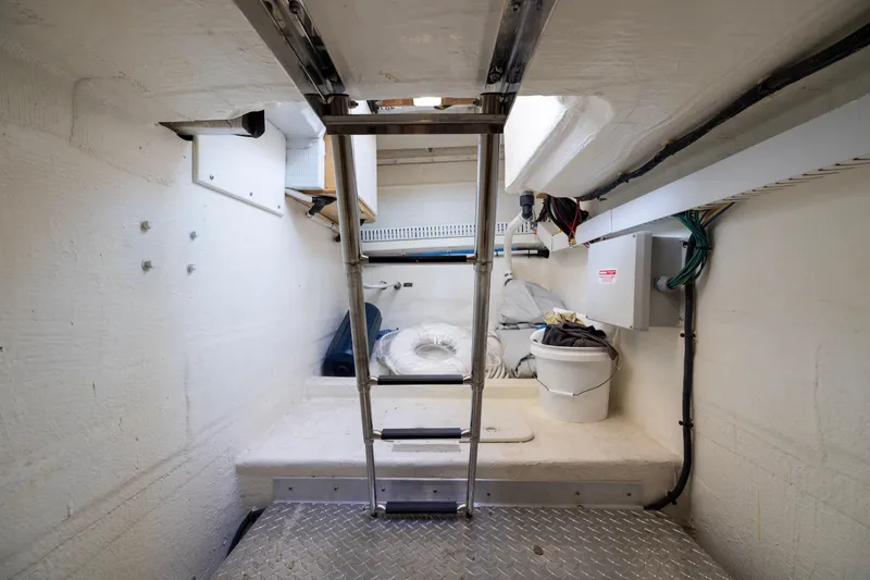 Slide: The Image of 2018 Back Cove Downeast 37 engine room with ladder and storage space. - 25
